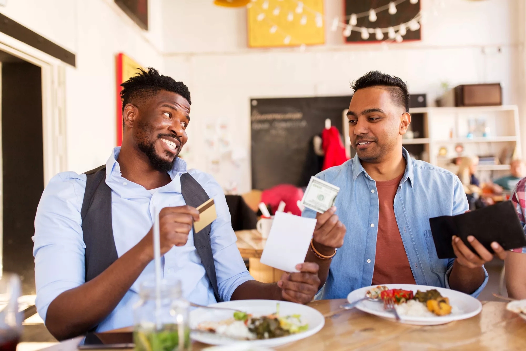 Two people arguing over who is paying the check for lunch.